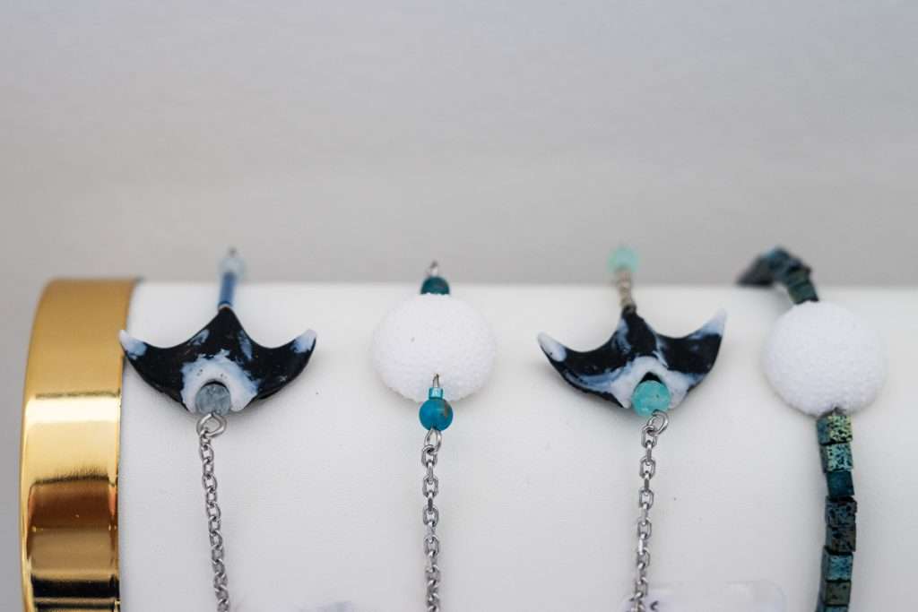 Bracelets ornés de breloques en forme de raie manta, créations artisanales exposées à la galerie AQUA