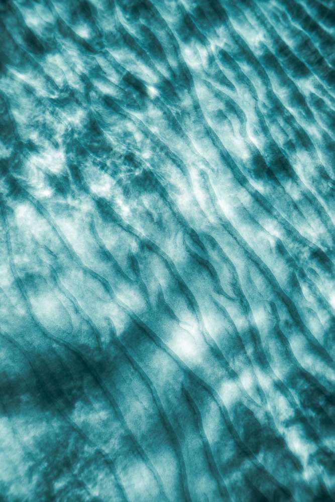 Empreinte marine : reflets de lumière sur le sable, sous l'eau