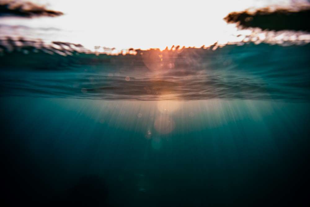 Rayon, photographie aquatique d'art : un soleil couchant vu depuis l'eau