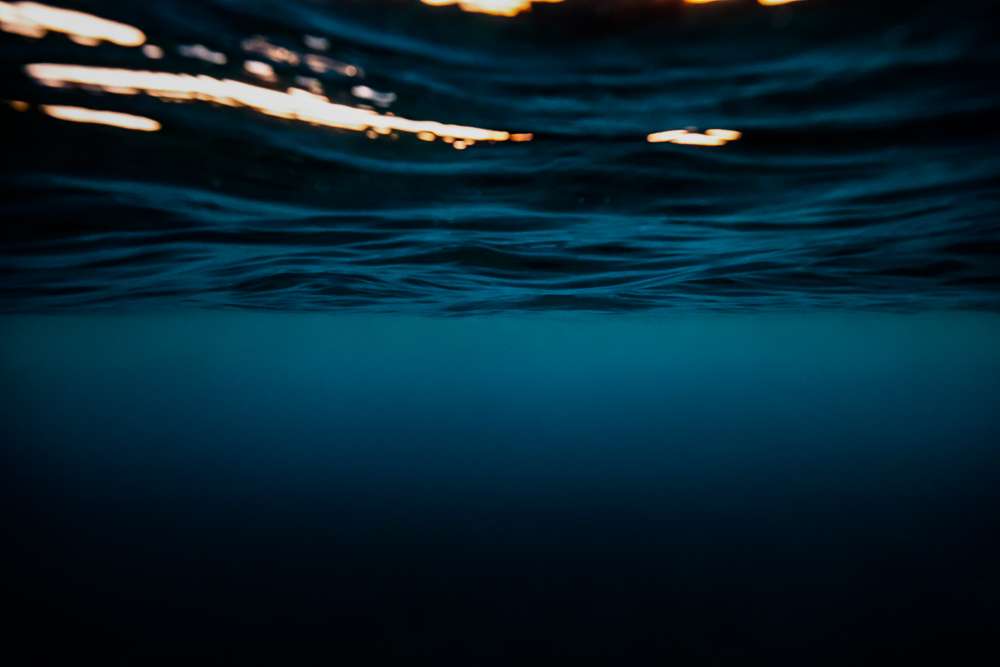 Surface : la limite entre l'air et l'eau, sous les lueurs du soleil couchant